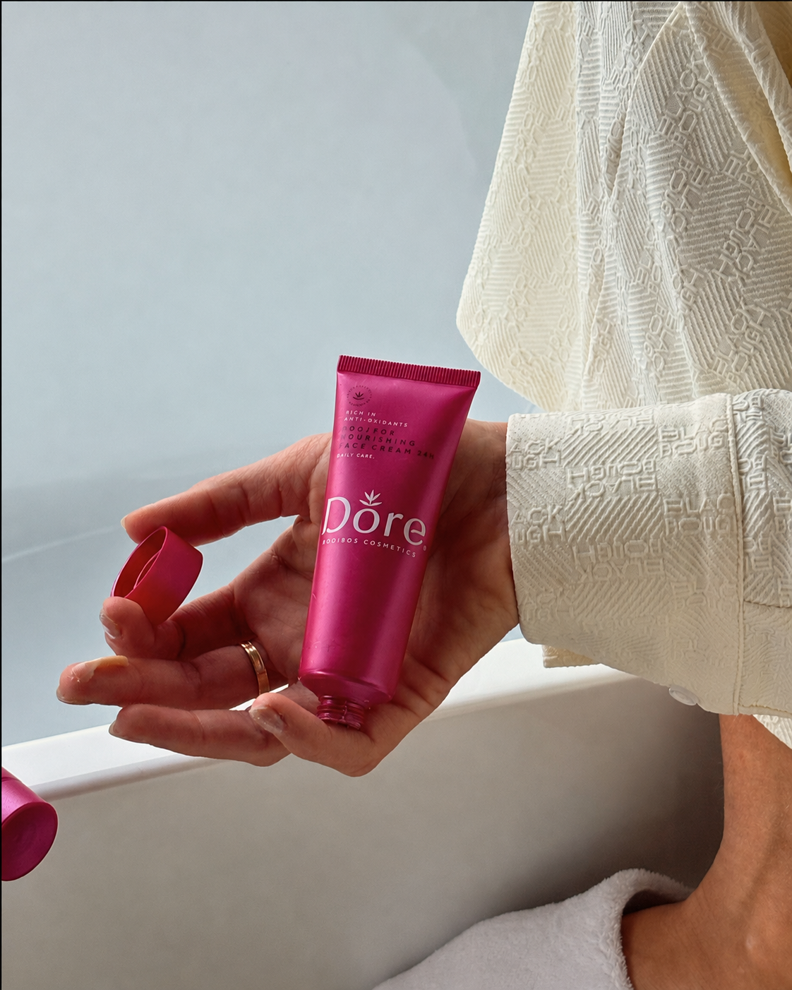 Dore Rooibos 24h creme liggend in een hand. 